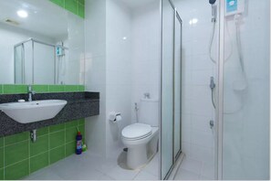 A bathroom with a sink, toilet, and glass-enclosed shower.
