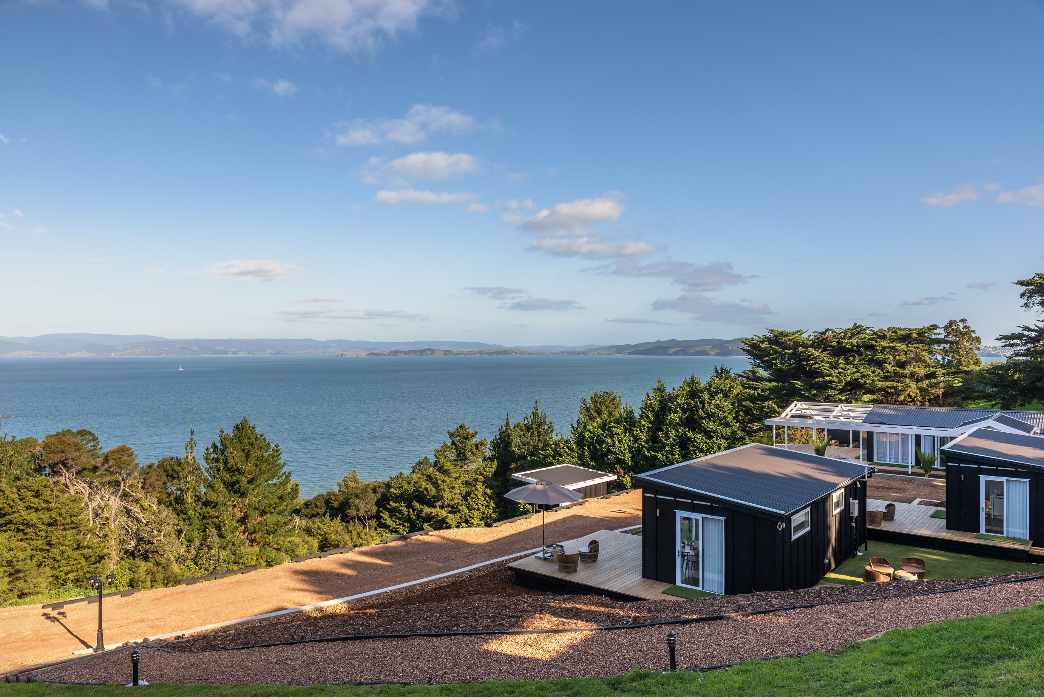 A coastal property with multiple cabins, a deck, and a view of the sea.