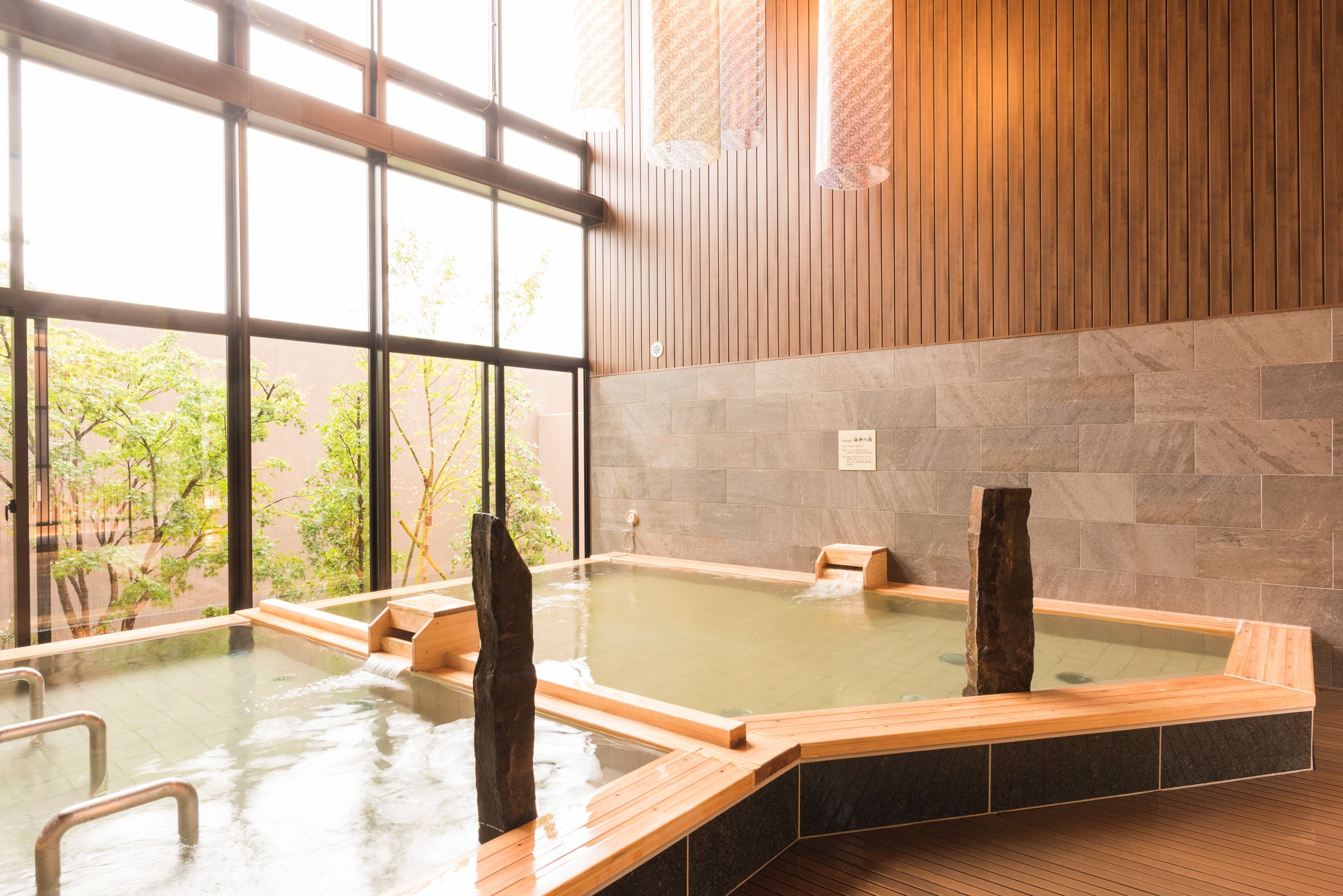 A hot spring area with wooden benches and a stone wall.