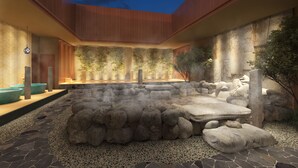 A hot spring area with stone seating and bamboo plants.