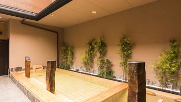 Un onsen japonés tradicional con bancos de madera y suelo de baldosas.