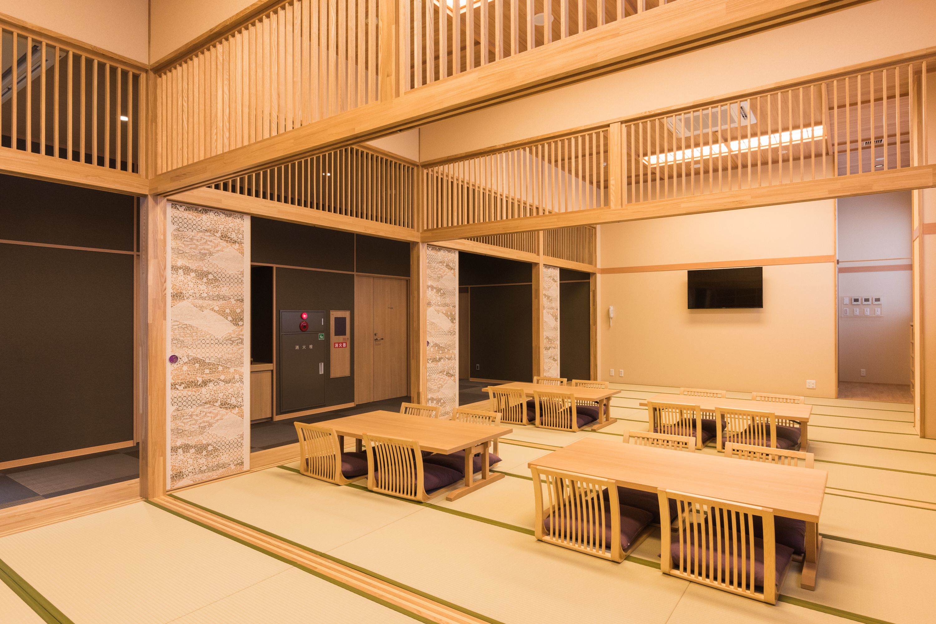 Una habitación tradicional japonesa con suelo de tatami, muebles de madera y puertas correderas.