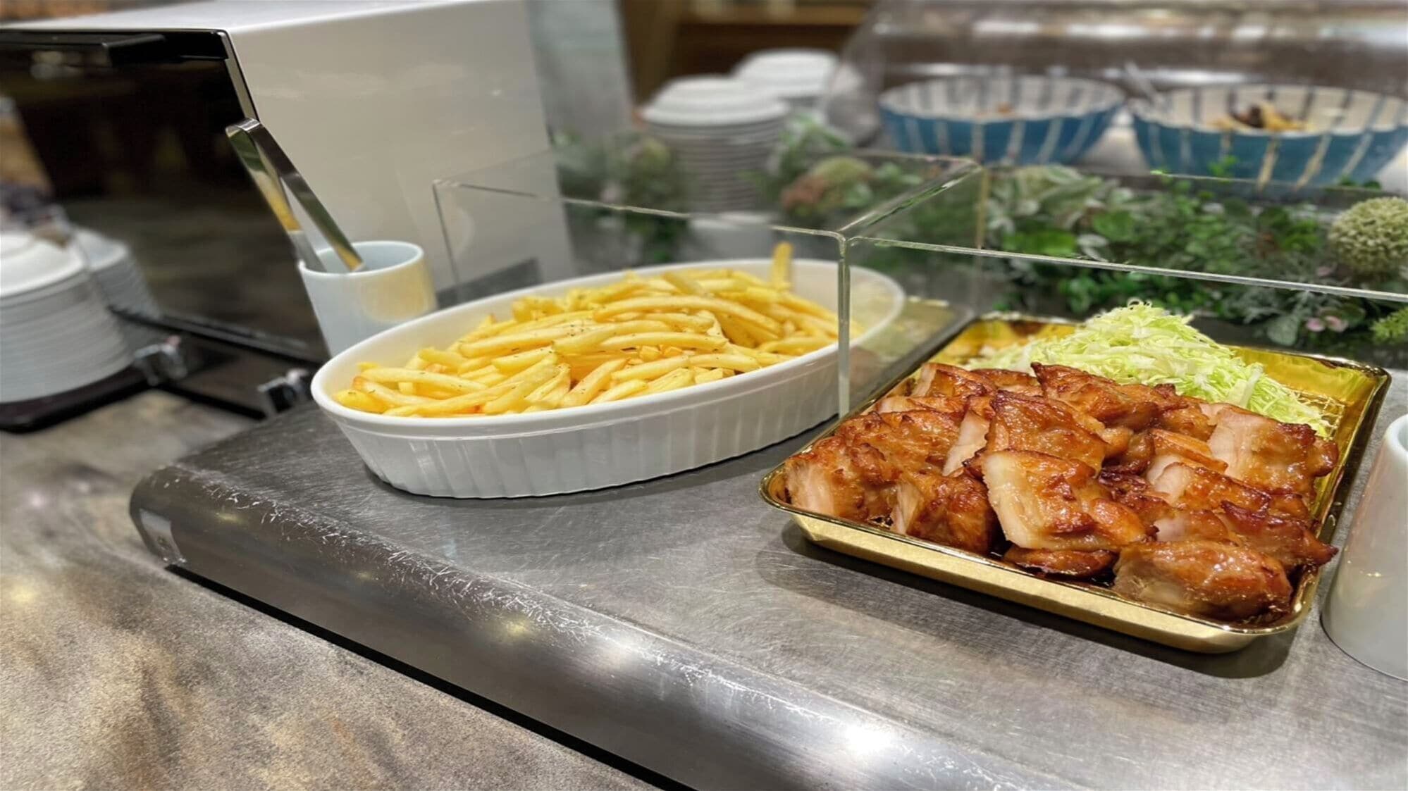 Un bufé con papas fritas, pollo asado y una ensalada.
