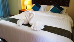 A hotel room with a neatly made bed, a headboard with a decorative panel, and a nightstand with a lamp. - Baan Maesot Boutique Resort (Mae Sot)