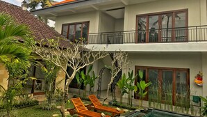 A two-story house with a swimming pool, a balcony, and lush greenery. - Umah Diuma (Ubud)