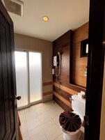 Une salle de bain avec une douche, des toilettes et un porte-serviettes.