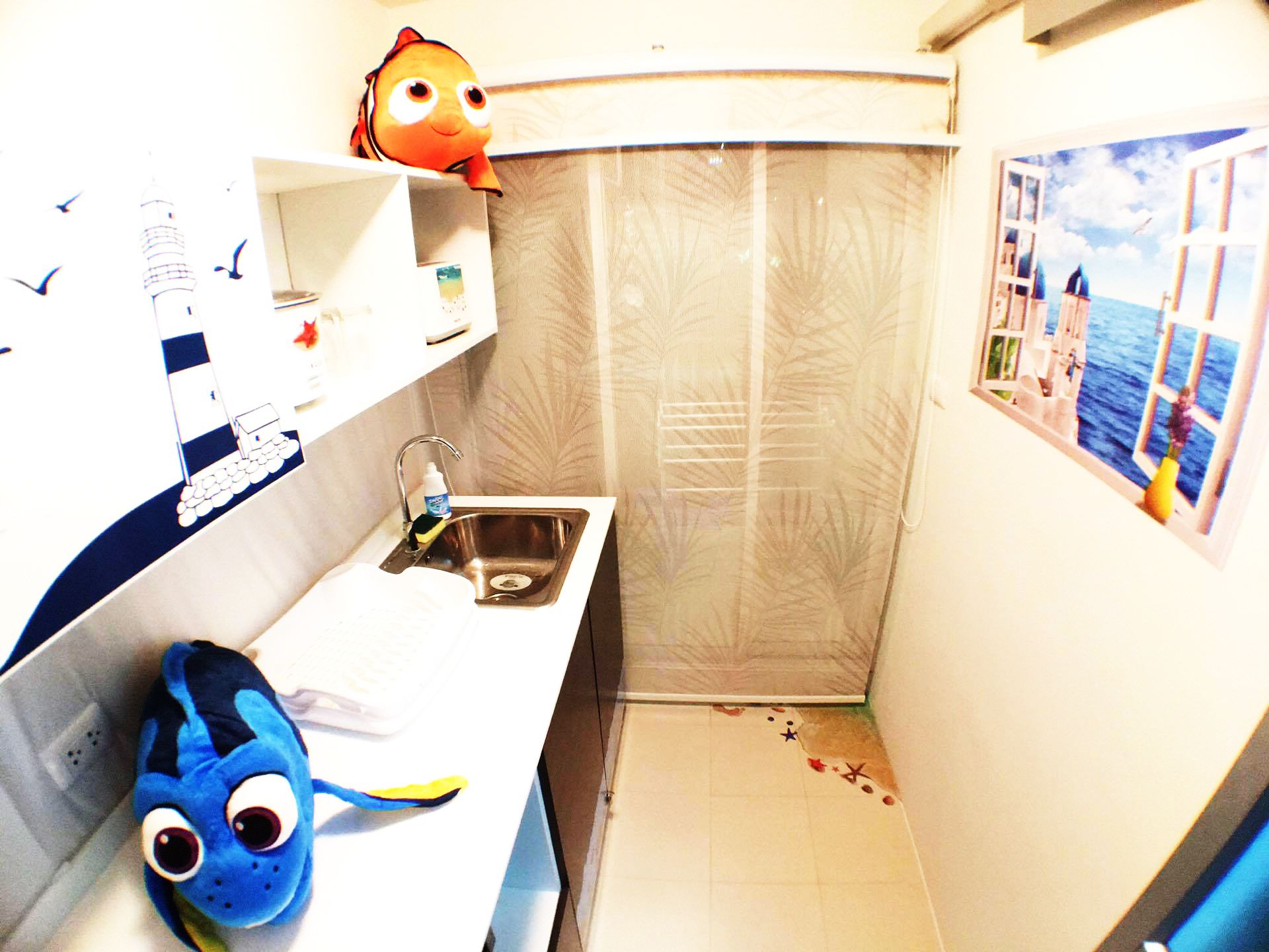 A small, narrow bathroom with a sink, a mirror, and a window with a view of the sea.