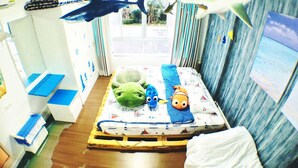 A child's bedroom with a bed, toys, and a window. - Marine Room At Baan Khun Koey Hua Hin (Hua Hin)