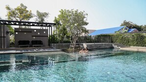 A clear swimming pool with a shaded seating area and a small slide. - Marine Room At Baan Khun Koey Hua Hin (Hua Hin)