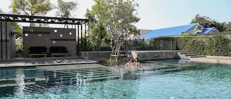 Una piscina al aire libre, tumbonas