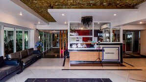 A modern lobby with a reception desk, seating area, and a decorative ceiling. - Latin Garden (Bangkok)