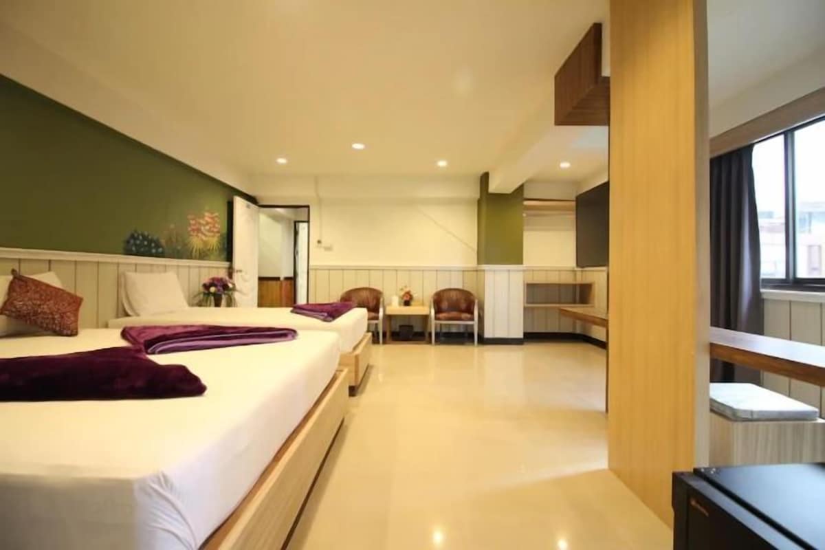 A hotel room with a large bed, a desk, and a view of the city.