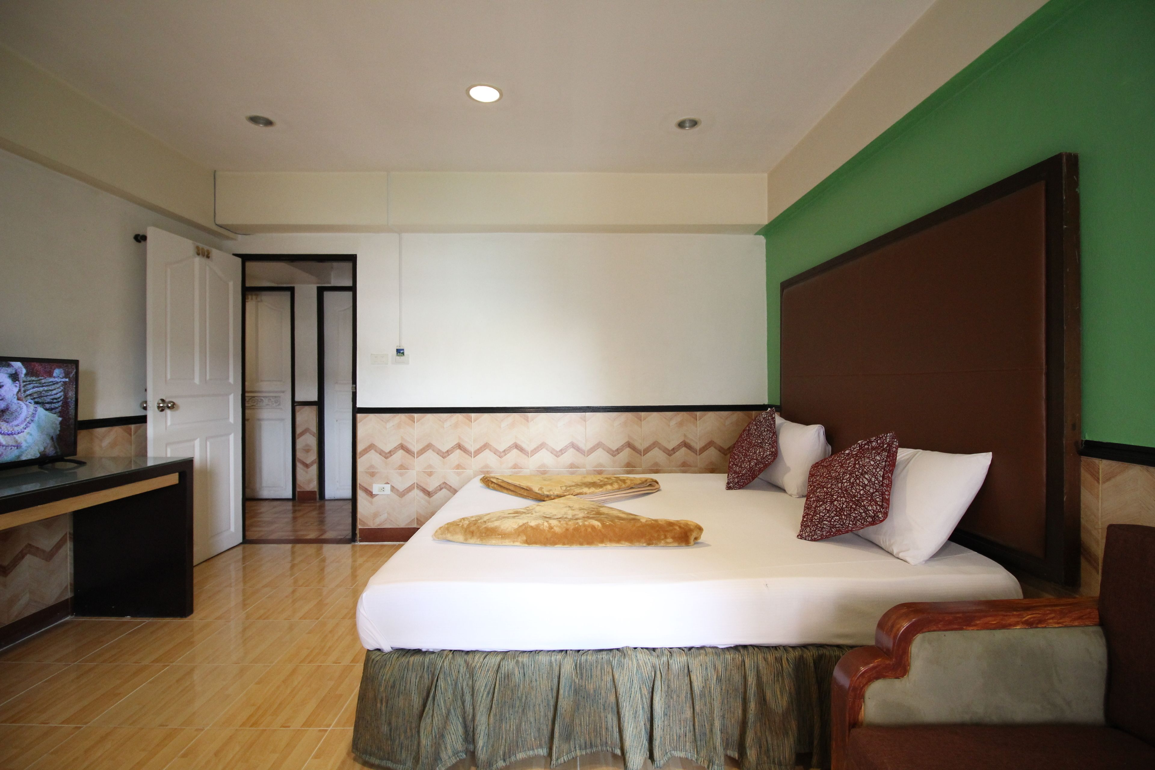 A hotel room with a bed, a TV, and a desk.