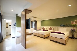 A modern hotel room with two beds, a TV, and a green accent wall. - Kaya Place (Bangkok)