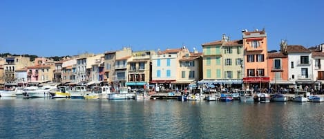 A waterfront with colorful buildings and boats docked along the shore.