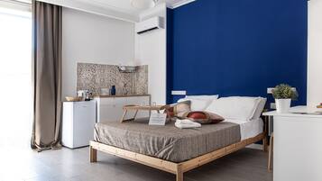 Ein modernes Schlafzimmer mit Bett, Nachttisch und kleinem Schreibtisch.