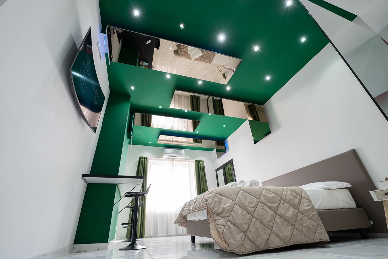 A modern bedroom with a bed, a TV, and a balcony.