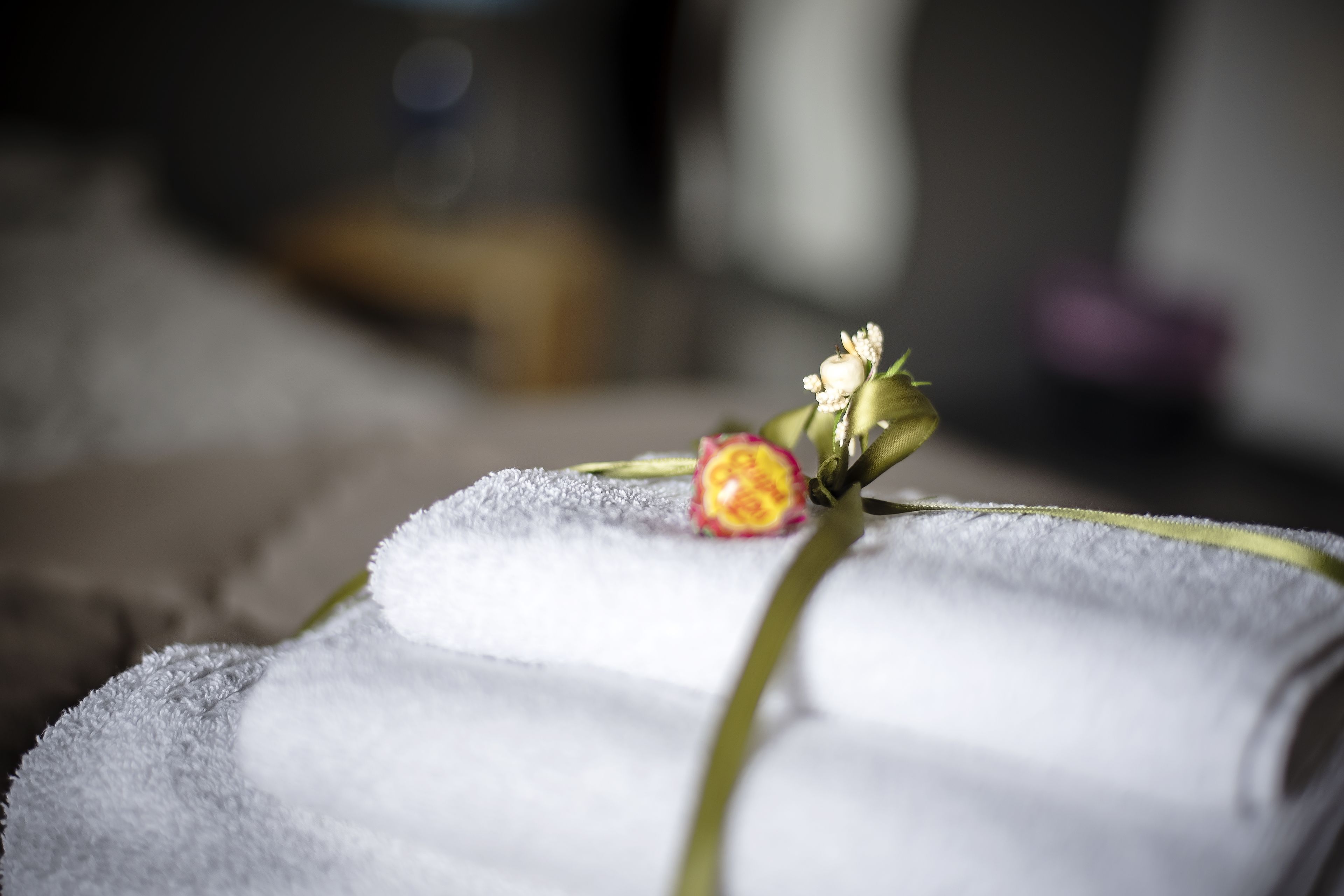 Gros plan d’une serviette ornée d’une fleur décorative, probablement dans un spa ou un hôtel.