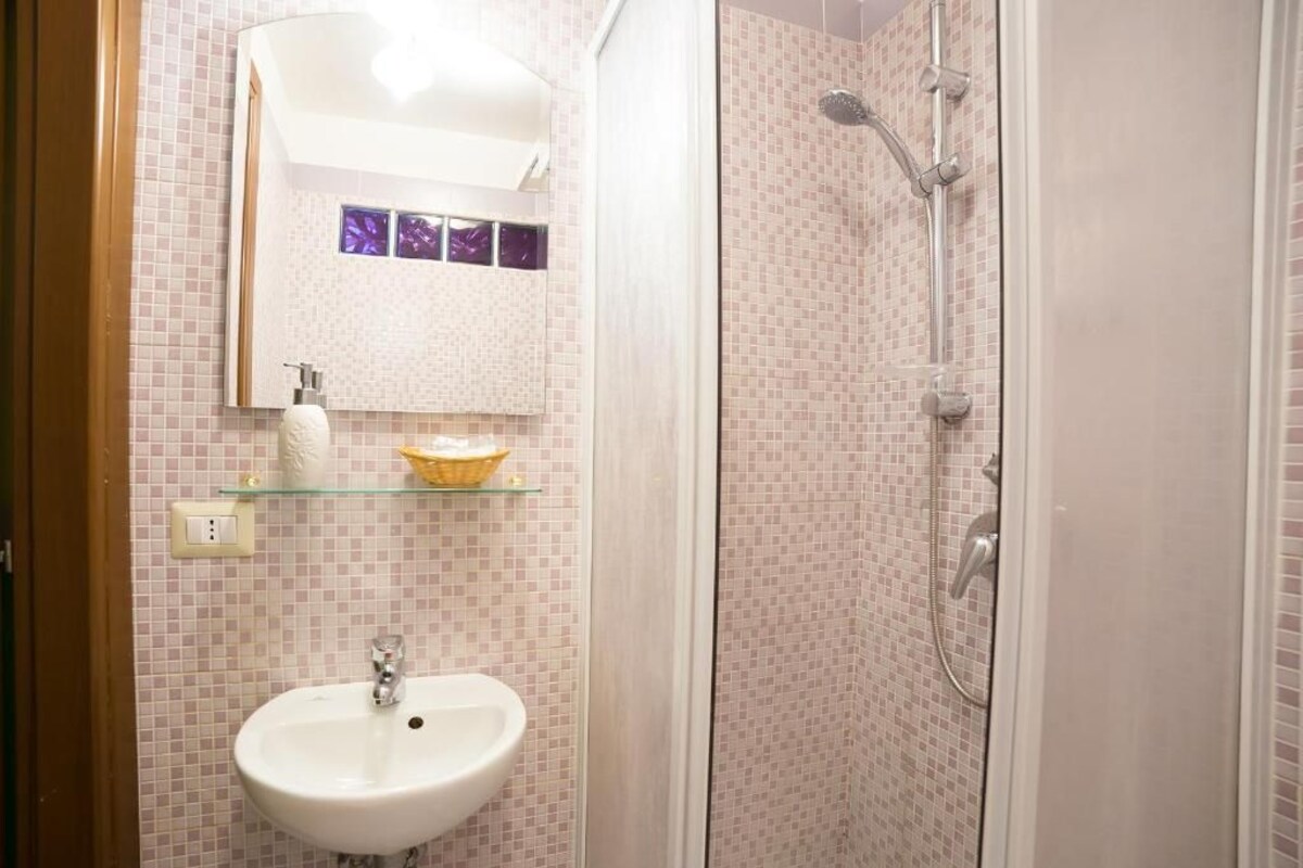 Une salle de bain avec un lavabo, un miroir et une douche.