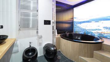 Une salle de bain moderne avec une grande baignoire, des toilettes et un bidet.