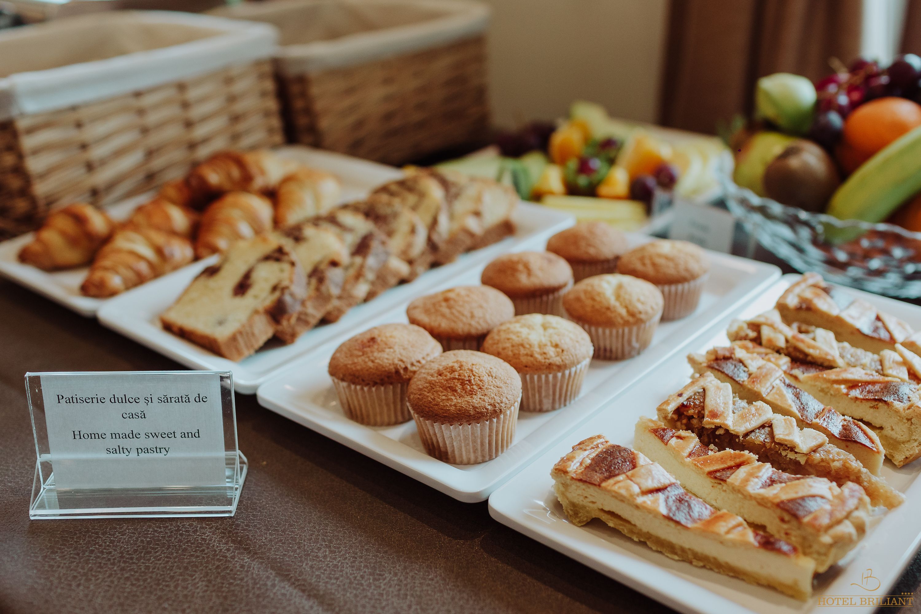 Una mesa de bufé con pasteles, muffins y un letrero que indica que la comida es casera.