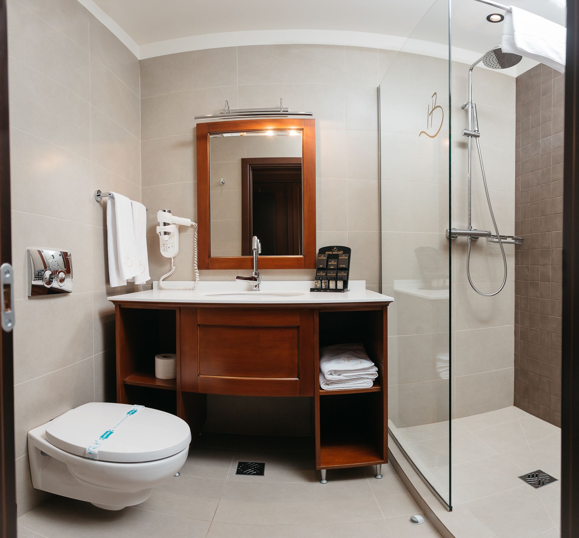A modern bathroom with a toilet, sink, and shower.