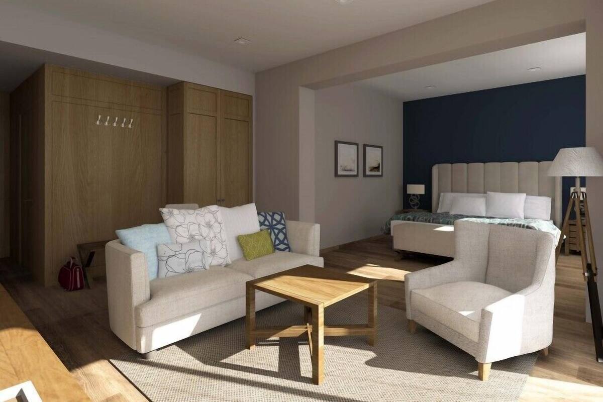 Ein modernes Wohnzimmer mit einer Couch, Sesseln, einem Couchtisch und einem Bett mit Kopfteil. Holzschränke und eine Stehlampe sind ebenfalls vorhanden.