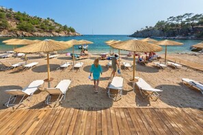 Aan een privéstrand, ligstoelen, parasols, strandlakens