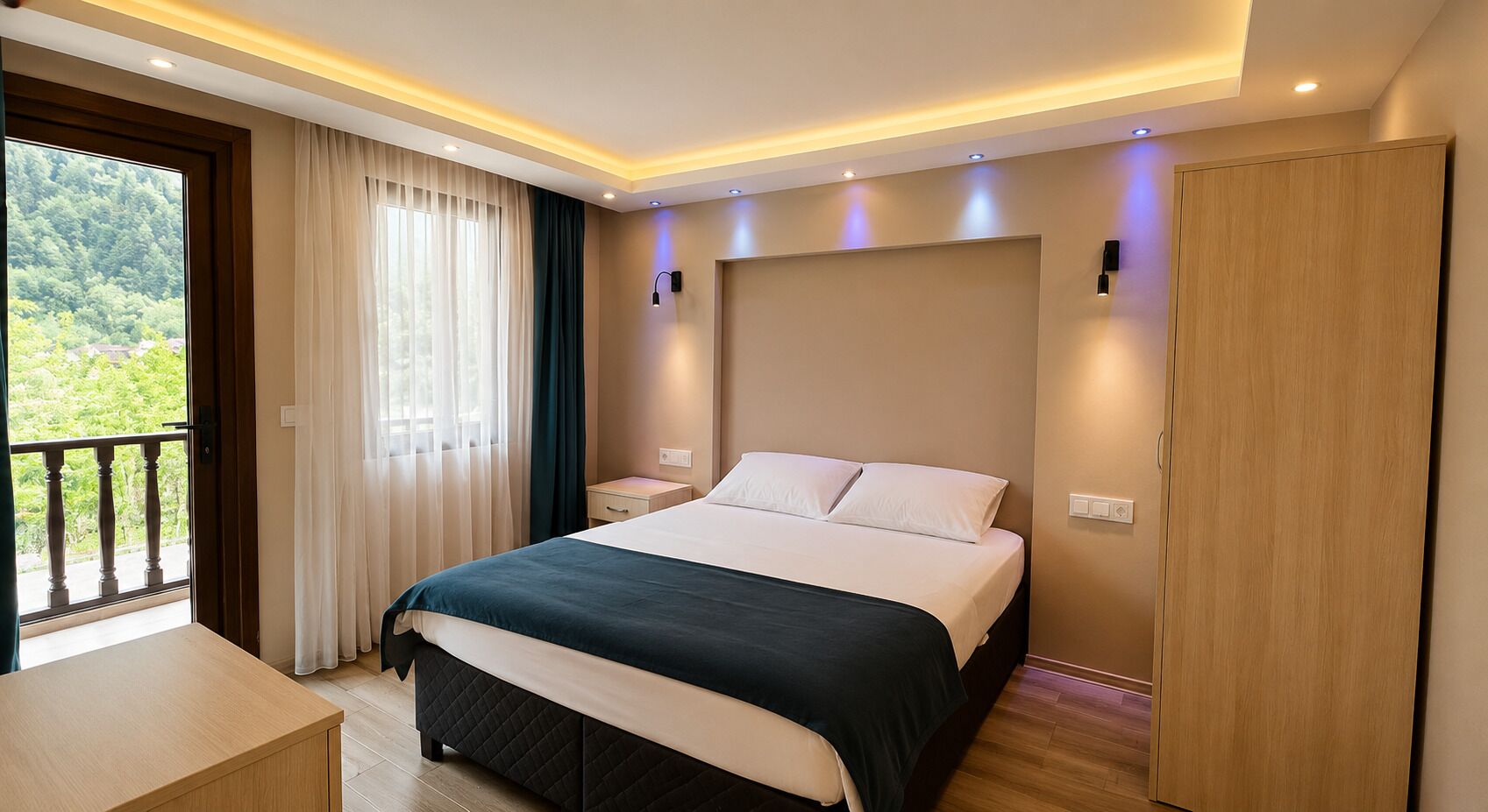 Quarto de hotel moderno com uma cama grande, uma mesa de cabeceira, uma escrivaninha e vista para o verde lá fora.