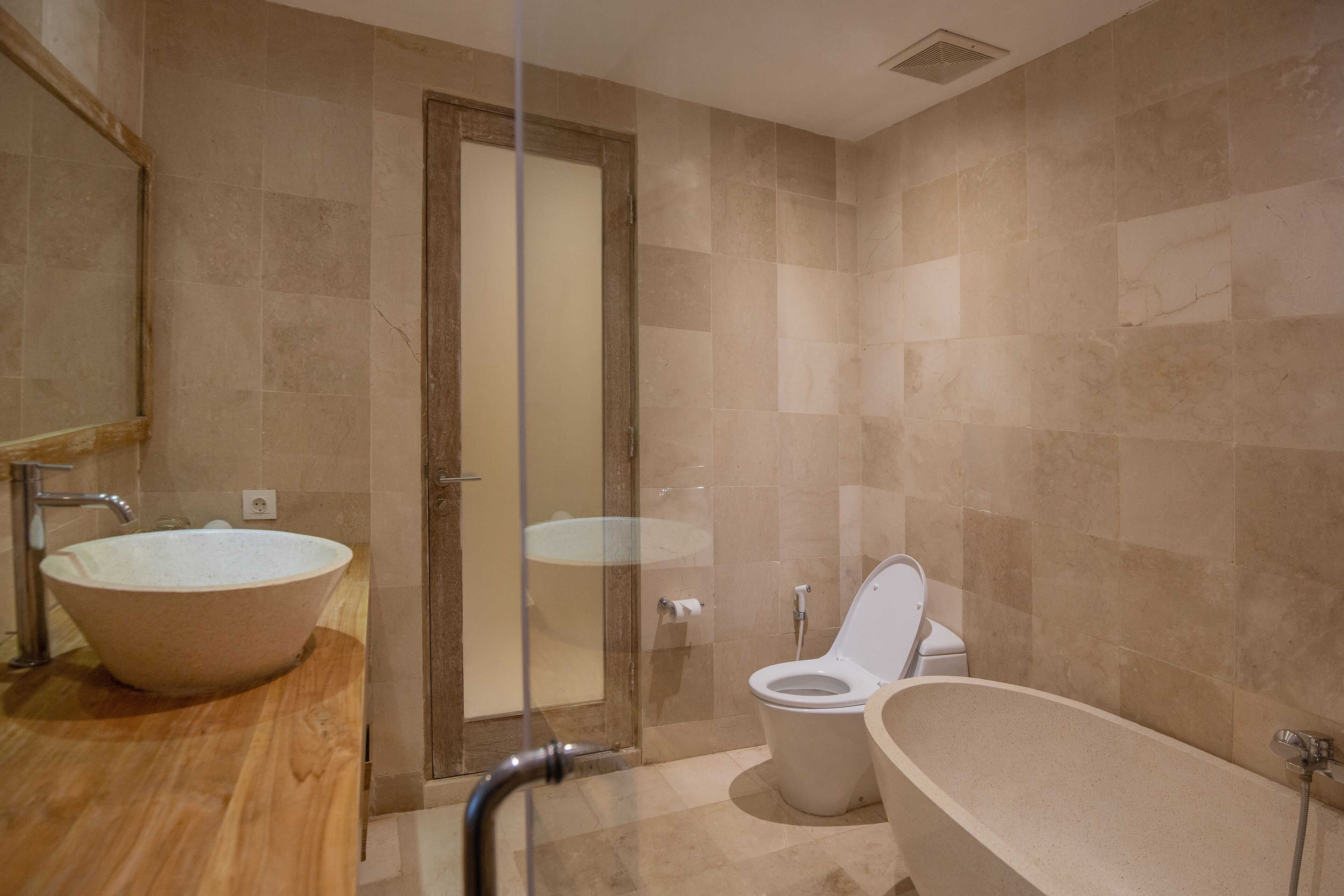 A bathroom with a large freestanding bathtub, a glass-enclosed shower, and a toilet.