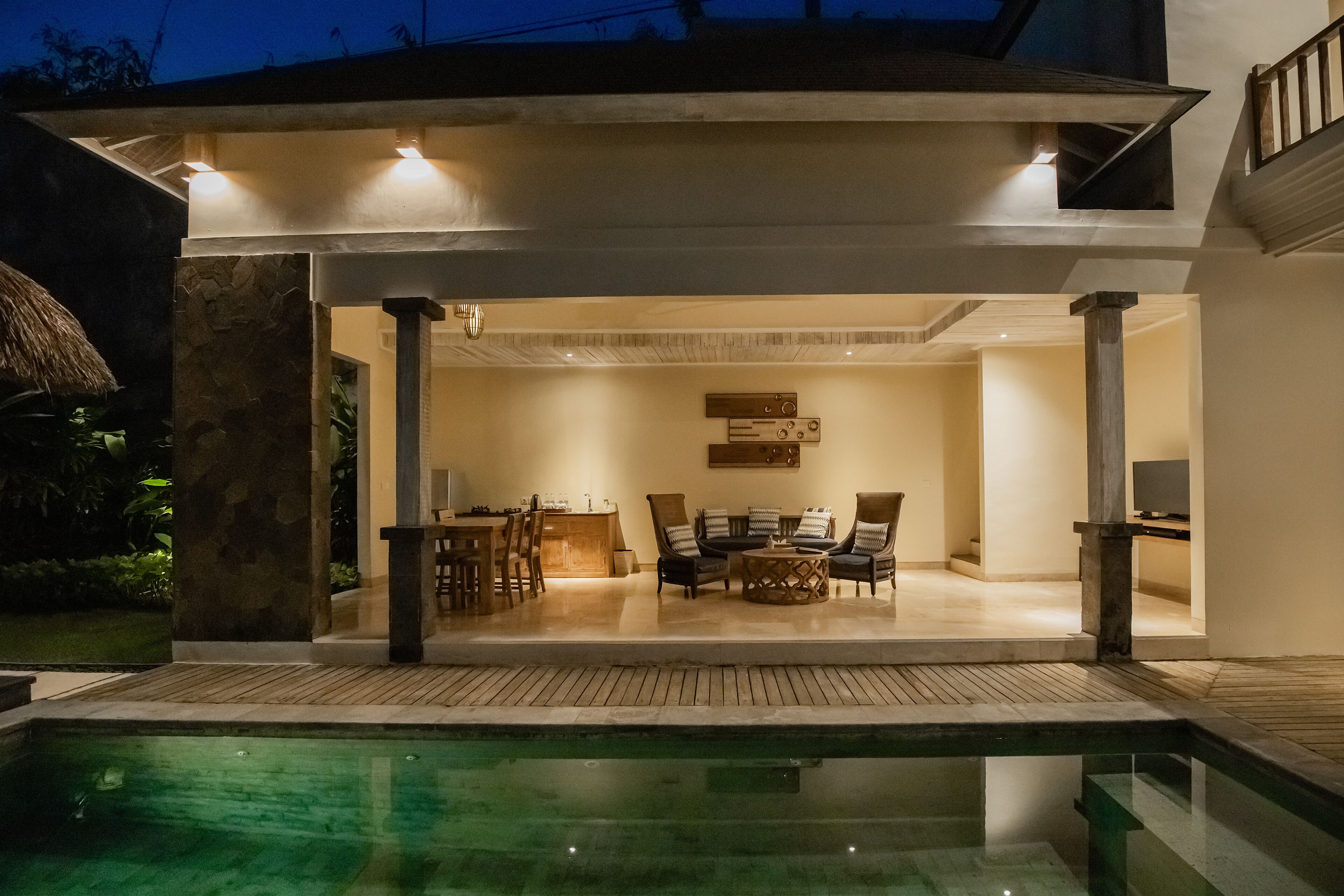 A modern house with a pool, outdoor seating, and a dining area.