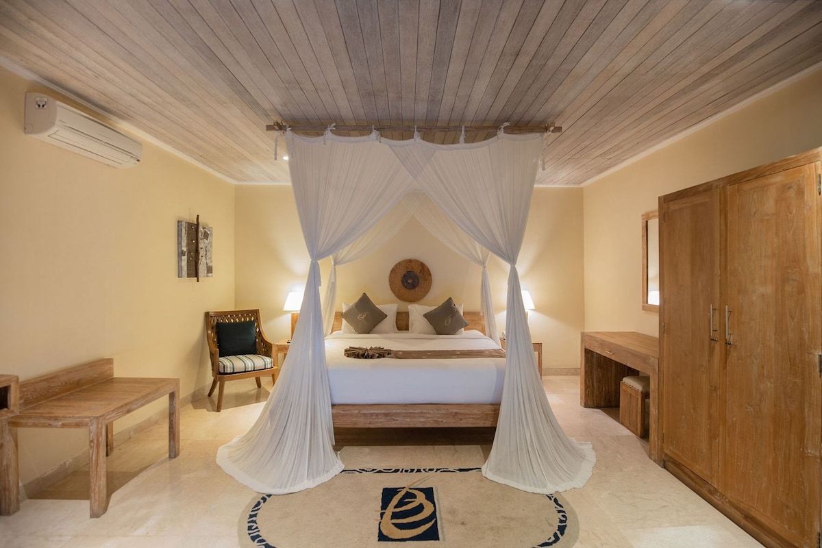 A bedroom with a four-poster bed, wooden furniture, and a large wardrobe.