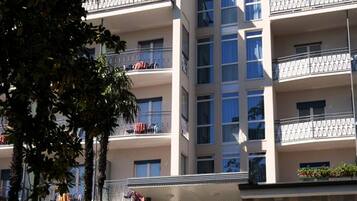 Un hôtel à plusieurs étages, reconnaissable à son enseigne bien visible où l’on peut lire « HÔTEL ALPI ».