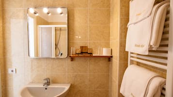 A bathroom with a sink, mirror, and towel rack.