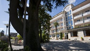Un hotel con fachada moderna, varios balcones y un patio espacioso.