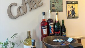 Zona de bar con cartel de café, pizarra de menú y diversas botellas de alcohol.