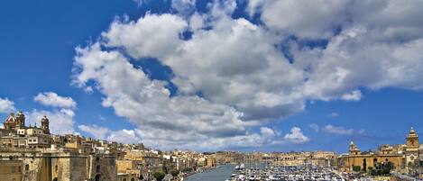 A harbor with boats, a historic building, and a clear sky.
