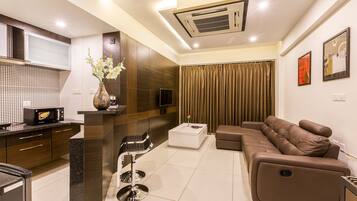 Habitación doble ejecutiva de uso individual, 1 habitación, cocineta, vista a la ciudad | Área de sala de estar | Televisión