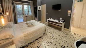 Une chambre d’hôtel avec un lit, une télévision, un bureau et une porte.