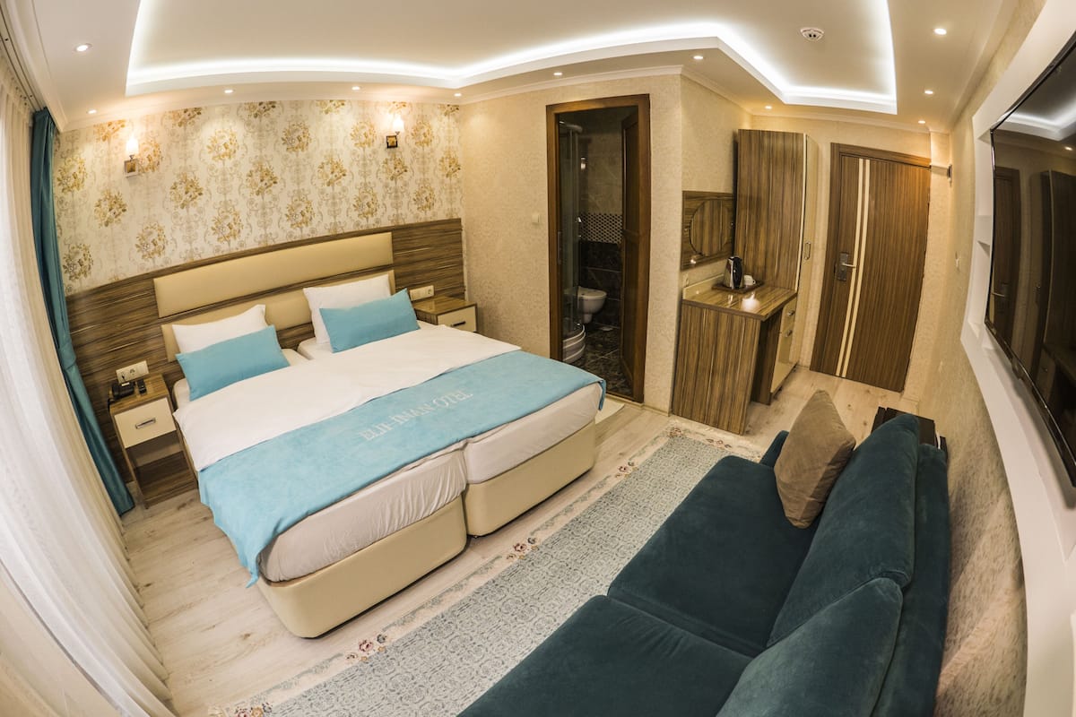 A modern bedroom with a large bed, a sitting area, and a bathroom.