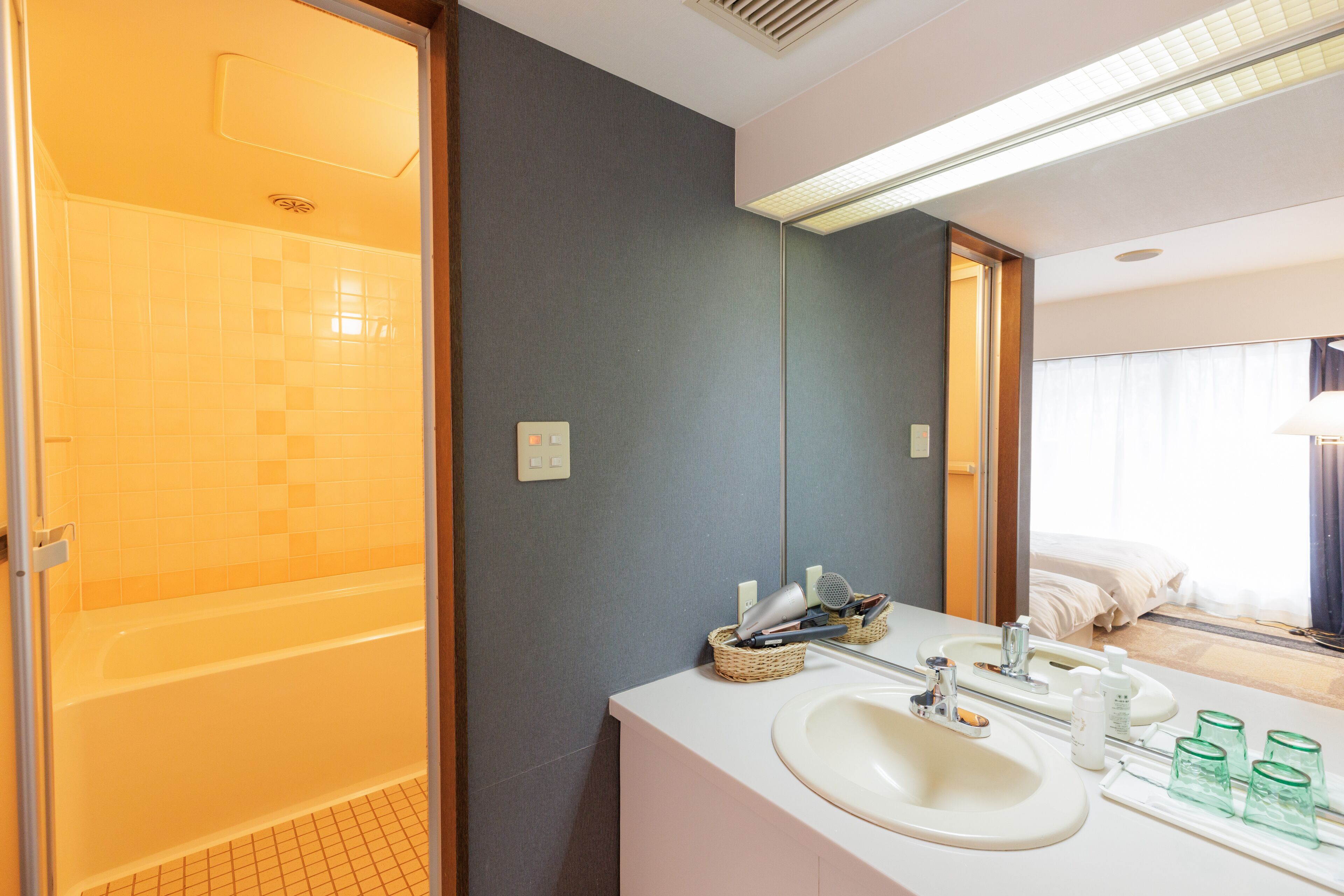 Un baño moderno con bañera, lavamanos con espejo y artículos de aseo.
