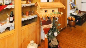 A room with wooden cabinets, a small wooden house model, and various decorative items including animal skulls and a lantern. - Hotel Schlossgasthof Artstetten (Artstetten)