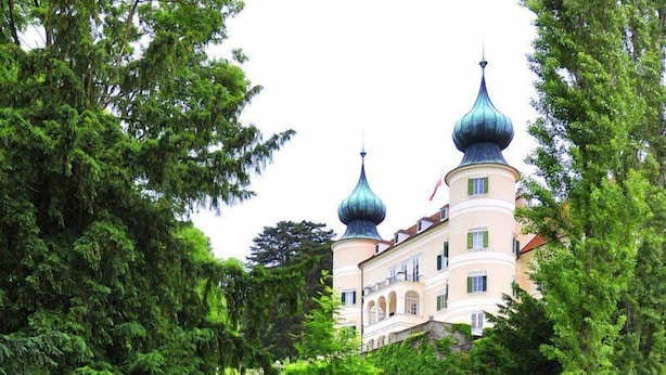 A large, multi-story building with a central tower and two smaller towers, surrounded by lush greenery. - Hotel Schlossgasthof Artstetten (Artstetten)