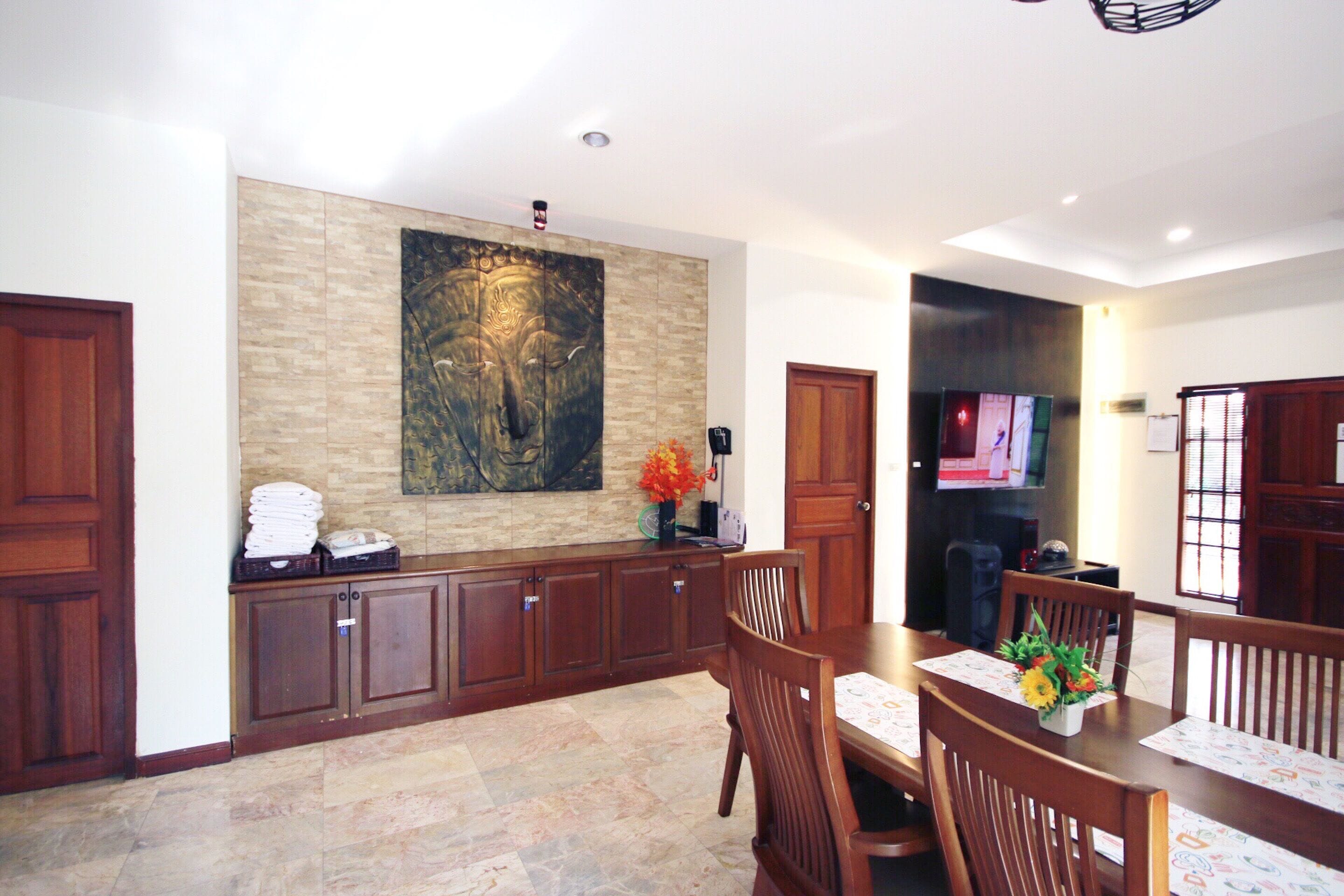 A dining area with a wooden table, chairs, and a large abstract painting on the wall.