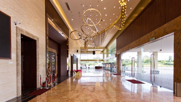 A spacious lobby with a marble floor, a modern chandelier, and a view of the outdoors. - MBI Desaku Homestay (Karangan)