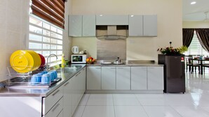 A modern kitchen with a dishwasher, microwave, and refrigerator. - MBI Desaku Homestay (Karangan)