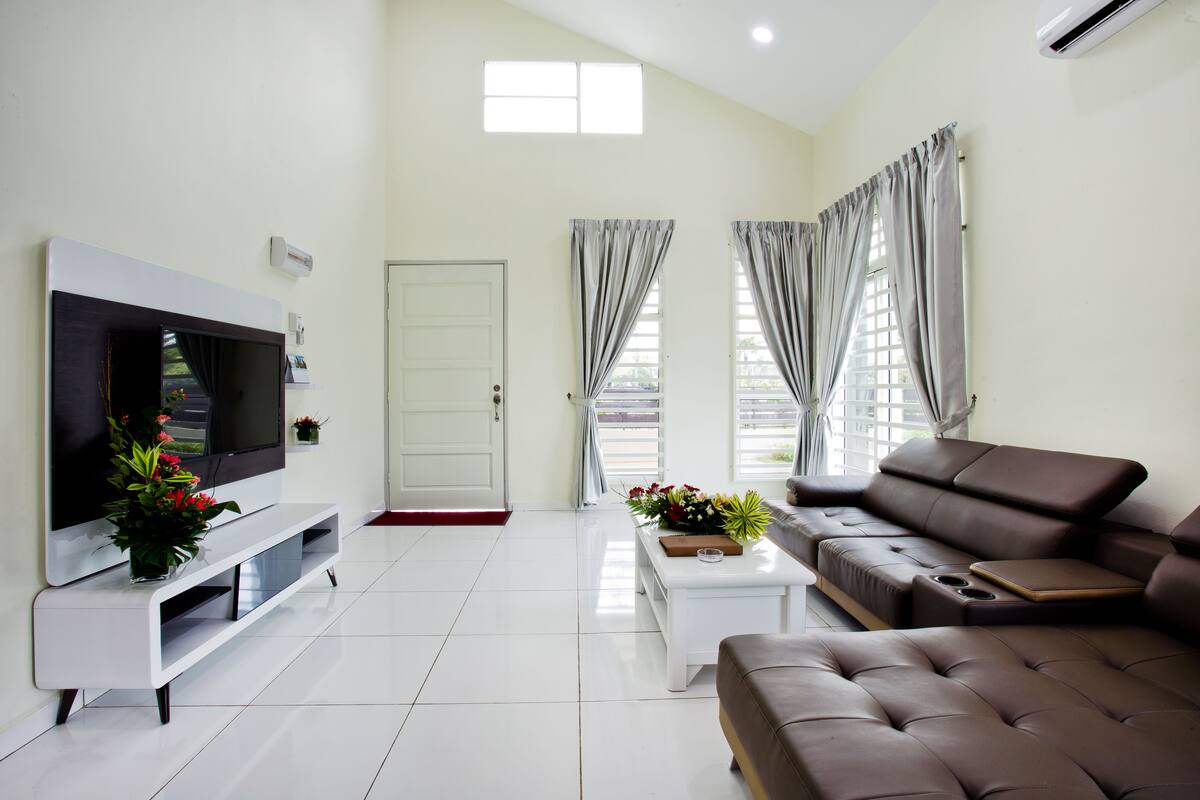 A modern living room with a flat-screen TV, a sofa, a coffee table, and a TV stand.