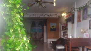 Una habitación con ventilador de techo, una planta en maceta, una mesa de comedor y una silla.