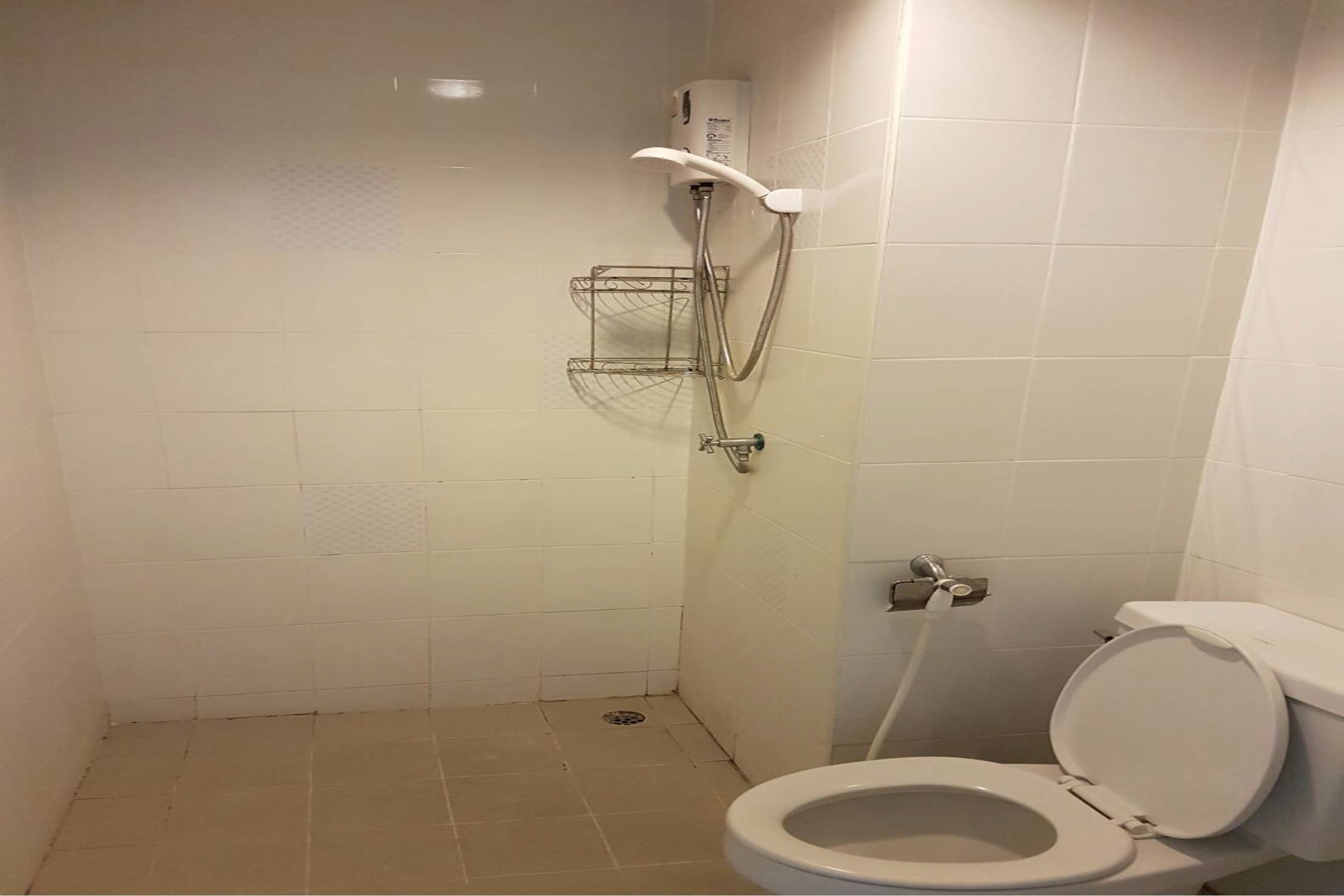 A small bathroom with a toilet, a shower, and a metal shelf.