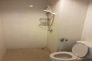 A small bathroom with a toilet, a shower, and a metal shelf.